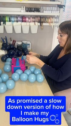 a woman sitting at a table with balloons in the shape of a train and text that reads, as promised a slow down version of how i make my balloon hugs