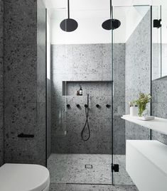 a bathroom with a shower, toilet and sink in it's own area is shown