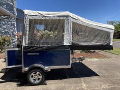 an enclosed trailer parked in front of a house