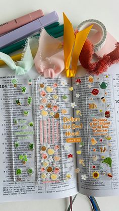 an open bible with paper clips, scissors and other crafting supplies laid out on it