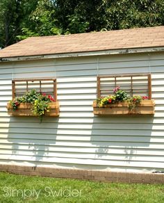 three flower boxes on the side of a white building