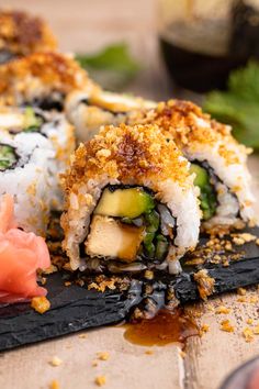 some sushi is sitting on a black plate with sauce and garnishes