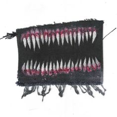 a piece of cloth with teeth on it and fringes hanging from the side,