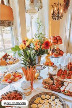 a table filled with lots of food on top of a white tablecloth covered table