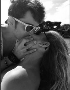 a man kissing a woman on the beach