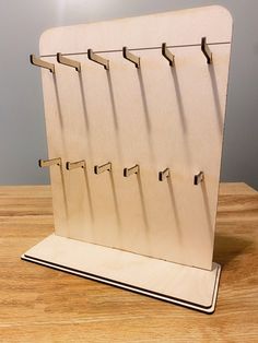 a wooden board with five hooks on it