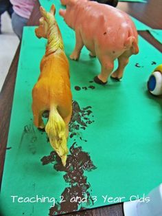 two plastic animals on top of a green table