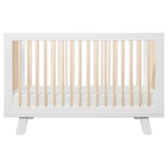 a white crib with wooden slats on the bottom and sides, against a white background