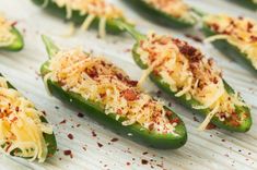 green peppers stuffed with cheese and seasoning on a baking sheet