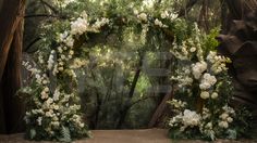 an outdoor wedding arch with white flowers and greenery on the sides, surrounded by trees