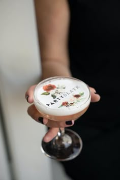 a woman holding a wine glass with flowers painted on the side and saying, i love you