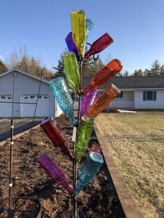 a multicolored glass tree in the middle of a yard