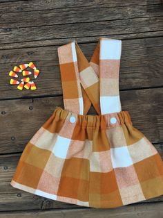 an orange and white checkered dress with candy corn on the side, next to it