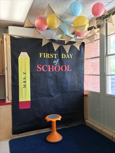 the first day of school sign is displayed in front of a bulletin board with crayons on it