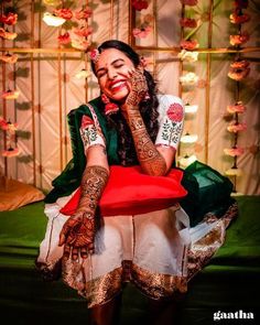 a woman sitting on top of a red chair covered in hendix and tattoos