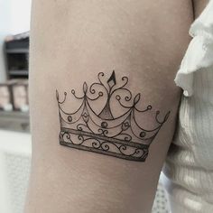 a black and white crown tattoo on the right thigh