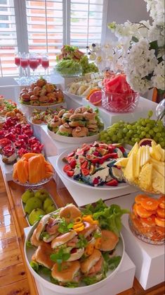 a table filled with lots of different types of food on plates and serving trays