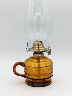 an old fashioned glass oil lamp on a white background