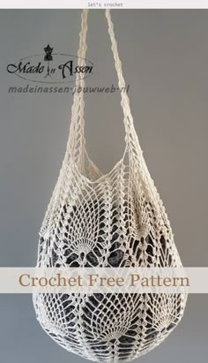 a white crochet bag hanging from a hook