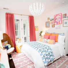 a bed room with a neatly made bed and a chandelier hanging from the ceiling