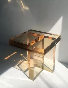 a glass table sitting in the middle of a room with sunlight coming through the window