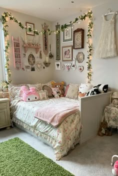 a bedroom decorated in pink and white with pictures on the wall