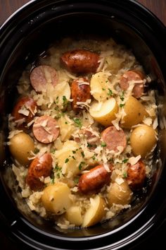 a crock pot filled with sausage and potatoes