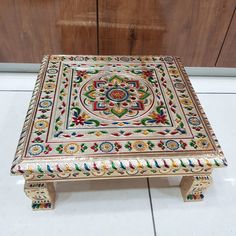 an intricately painted wooden table on the floor