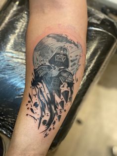 a man with a tattoo on his arm has a darth vader star in the background