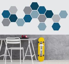 a yellow skateboard sitting in front of a wall with hexagons on it