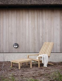 a wooden chair and foot stool in front of a building