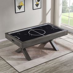 a foosball table sitting on top of a hard wood floor in a living room