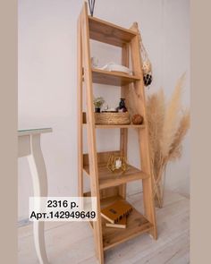 a wooden shelf sitting on top of a hard wood floor next to a white table