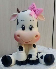 a cake that looks like a cow with a pink bow on its head