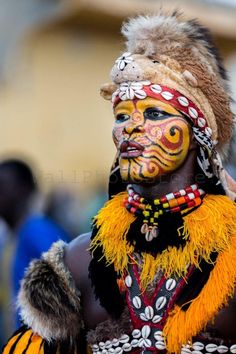 a person with painted face and headdress