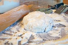 a ball of dough sitting on top of a table next to a rolling pin