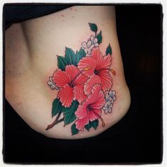 a woman's stomach with flowers and leaves tattooed on her side, in the shape of a flower