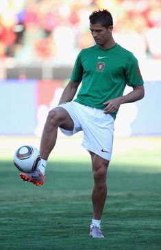 a man kicking a soccer ball on top of a field