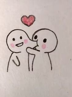 a drawing of two people holding each other with a heart above their heads on a piece of paper