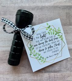 a card with a black and white ribbon tied around it next to a pair of binoculars