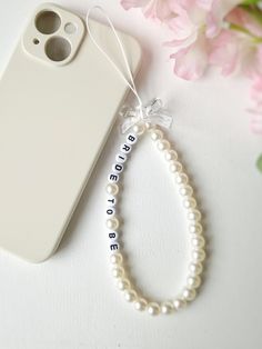 Elevate your phone's style with our custom pearl phone charm. Crafted with beautiful pearls and accented with a charming bow bead, this accessory adds a touch of elegance to your everyday look. Personalize your phone charm to make it uniquely yours. It can be used as a phone chain, phone keychain, or even a phone bracelet. Both functional and fashionable, it's an ideal gift for yourself or a friend. Embrace the trend of beaded phone straps with our customizable pearl phone charm today. Bracelet Telephone, Pearl Phone Charm, Phone Bracelet, Phone Keychain, Phone Chain, Bracelet Ideas, Telephones, Custom Keychain, Phone Charm