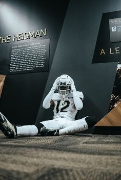 a football player sitting on the ground in front of a display