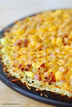 a casserole dish with cheese and bacon in it sitting on a counter top