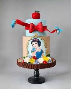 there is a cake decorated with an image of snow white and apple on the top