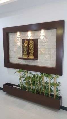 a wall mounted mirror with some plants in it