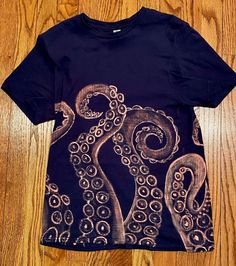 an octopus t - shirt on a wooden floor