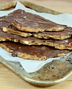 three pieces of chocolate and peanut butter on top of parchment paper