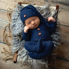 a newborn baby wearing a blue sweater and hat