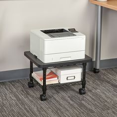 a white printer sitting on top of a table next to a shelf filled with files