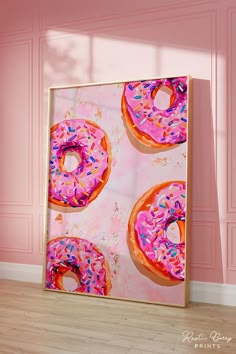 a painting of three donuts with pink icing and sprinkles on it